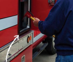 Rescue worker opening cabinet on fire rescue truck